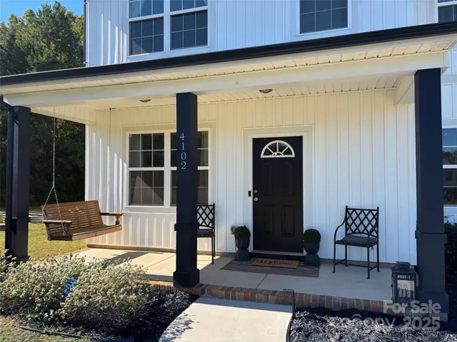 a front view of a building with garden and seating area