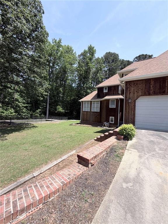763 McDaniel Mill Road Southwest Conyers, GA 30094 - Photo 79 of 80 a front view of a house with a yard and garage