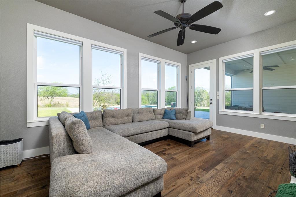 338 County Road 4223 Decatur, TX 76234 - Photo 21 of 37 2nd downstairs living room used as a Sunroom/Den. Windows overlook the pool and access to the patio. This space is located behind the main living room w see-thru fireplace.