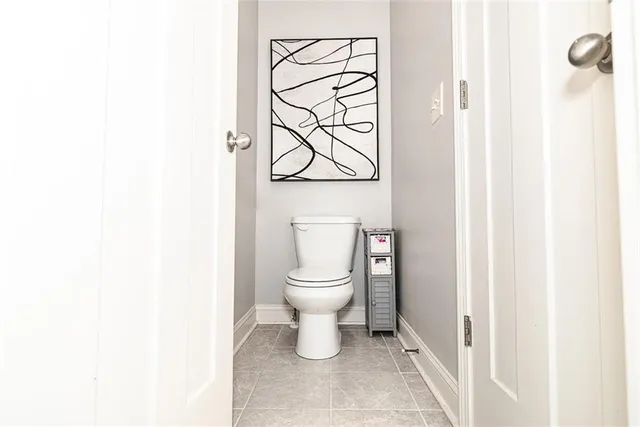 a bathroom with a granite countertop sink toilet and mirror