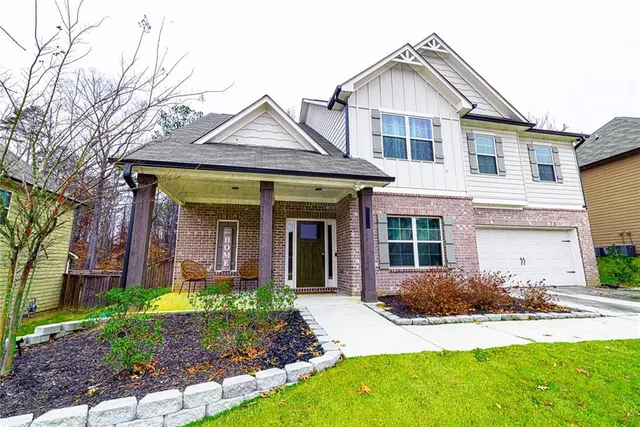 a front view of a house with a yard and potted plants