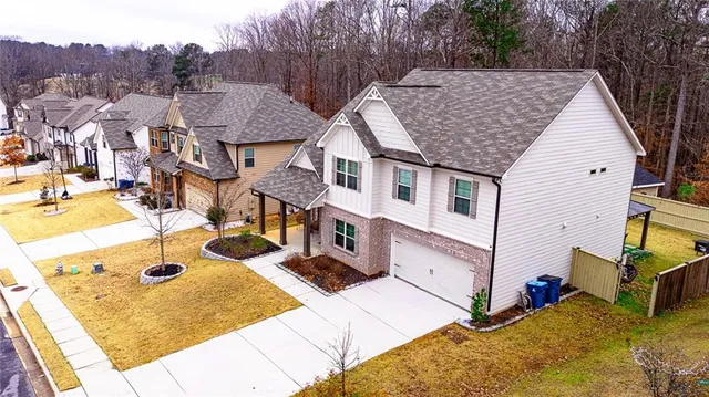 a view of a hallway with wooden floor and a bathroom