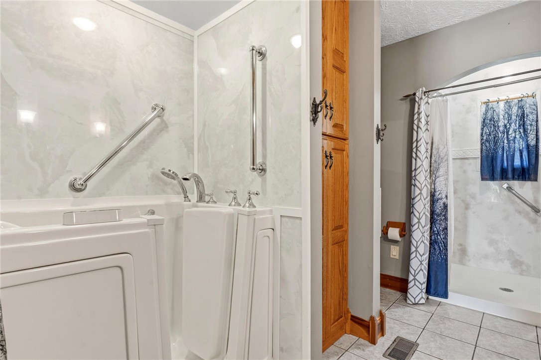 4971 Lackey Road Cedarville, OH 45314 - Photo 63 of 79 This bathroom features a walk-in tub and a separate shower, enhancing daily comfort and accessibility.