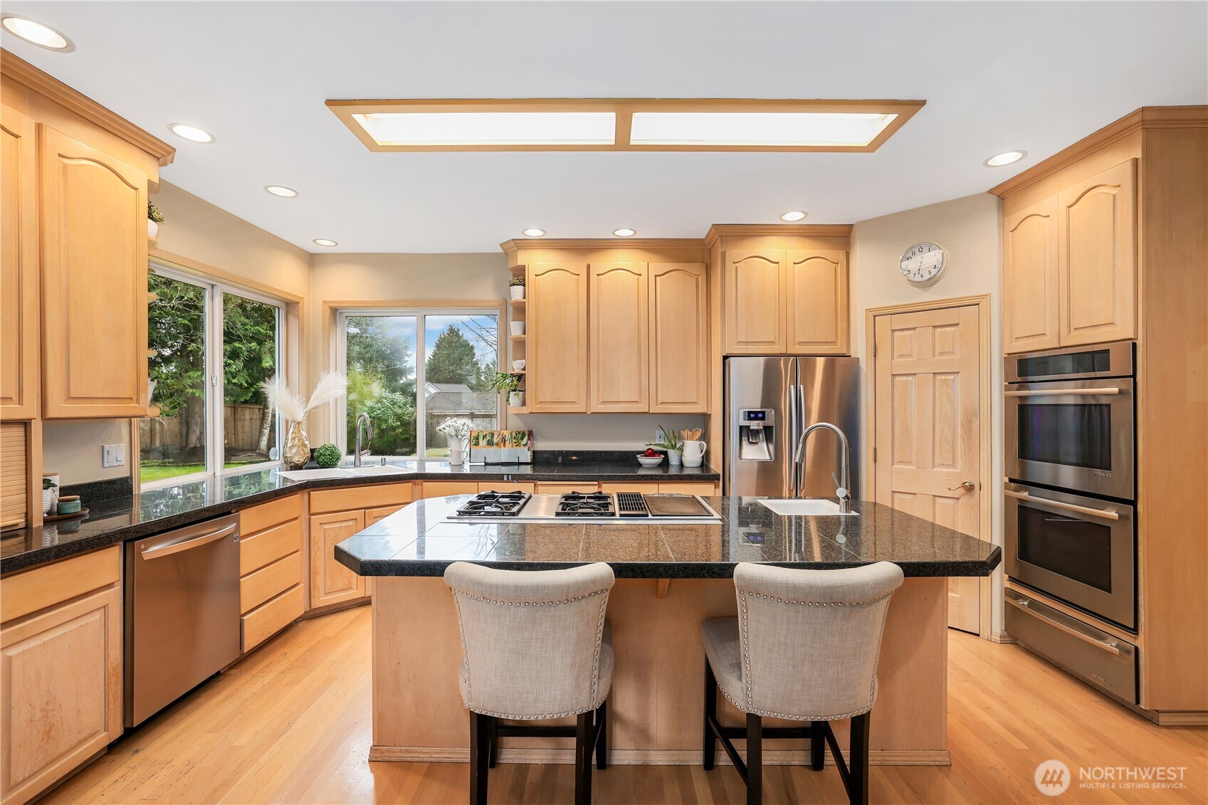 423 Southwest 348th Court Federal Way, WA 98023 - Photo 9 of 39 a kitchen with stainless steel appliances granite countertop a stove a refrigerator a sink and white cabinets with wooden floor