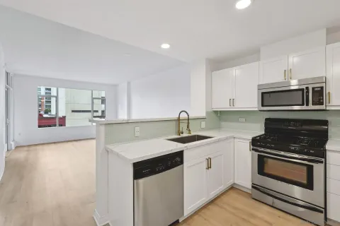 a kitchen with stainless steel appliances granite countertop a sink stove and cabinets