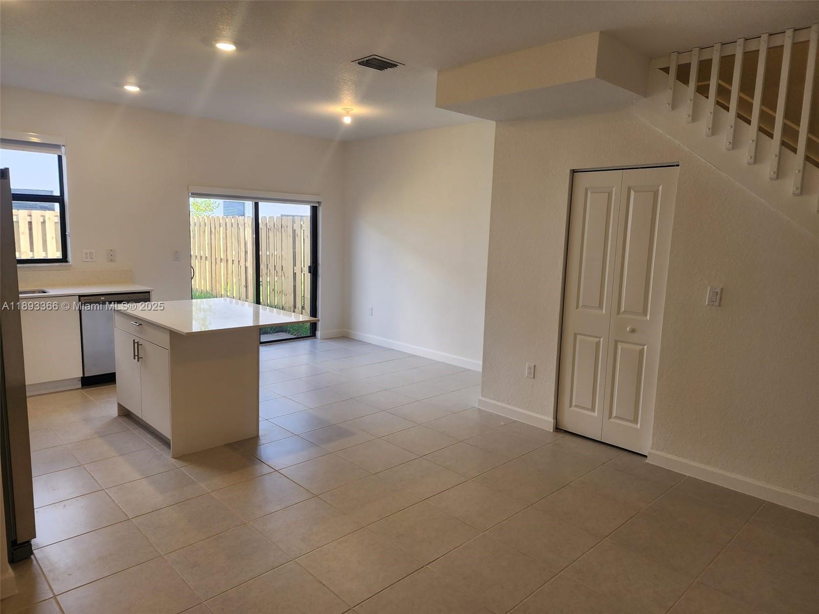 12867 Southwest 232nd Lane, Unit 12867 Homestead, FL 33032 - Photo 2 of 12 an empty room with windows and cabinet
