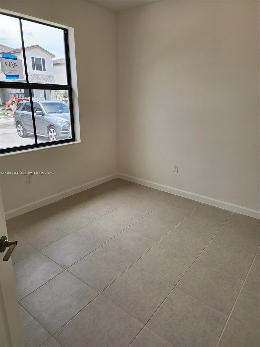12867 Southwest 232nd Lane, Unit 12867 Homestead, FL 33032 - Photo 3 of 12 an empty room with a window