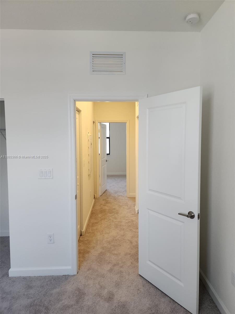 12867 Southwest 232nd Lane, Unit 12867 Homestead, FL 33032 - Photo 10 of 12 a view of a hallway with wooden shelves