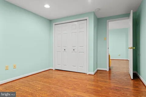 an empty room with wooden floor and closet