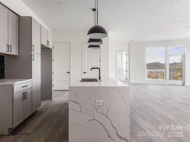 a kitchen with granite countertop a stove a sink and a refrigerator