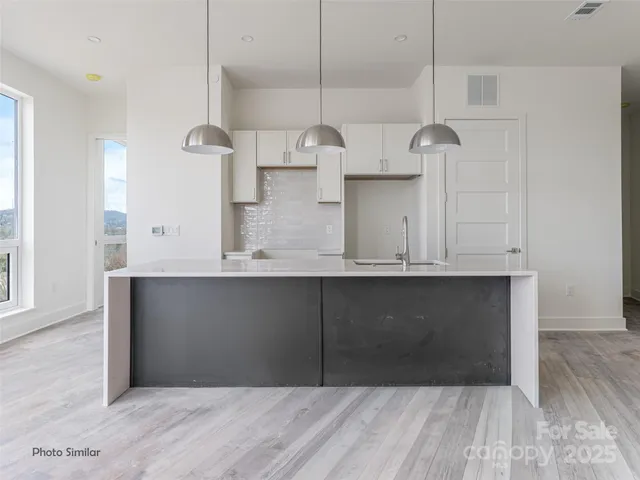 a kitchen with stainless steel appliances kitchen island a refrigerator and a sink