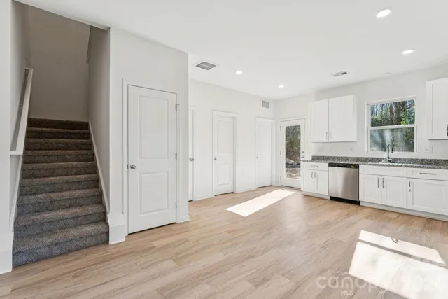a view of a kitchen with wooden floor and electronic appliances