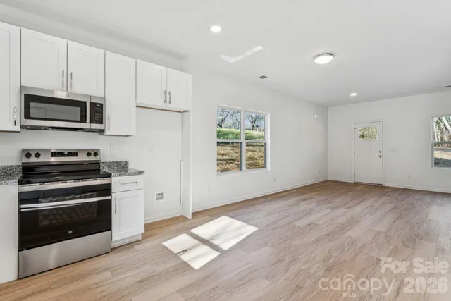 a view of kitchen with wooden floor and electronic appliances