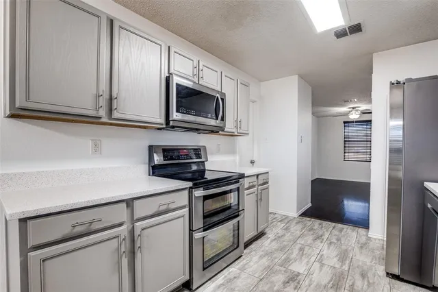 a kitchen with stainless steel appliances granite countertop a refrigerator stove and microwave