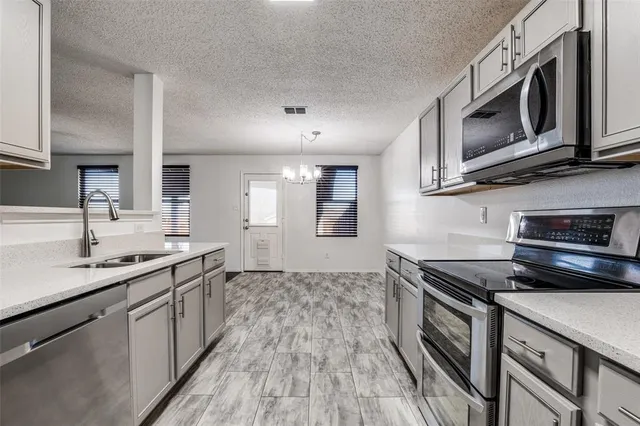 a kitchen with stainless steel appliances granite countertop a sink stove and microwave