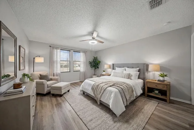 a spacious bedroom with a bed and wooden floor