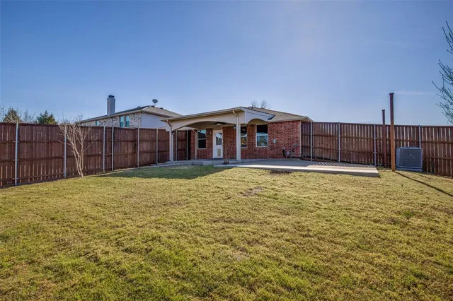 a view of a house with a backyard and a table and chairs