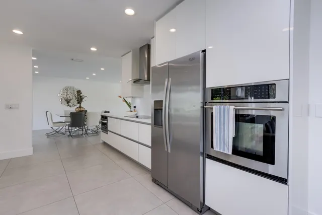 a bedroom with a flat screen tv on the dresser and a potted plant