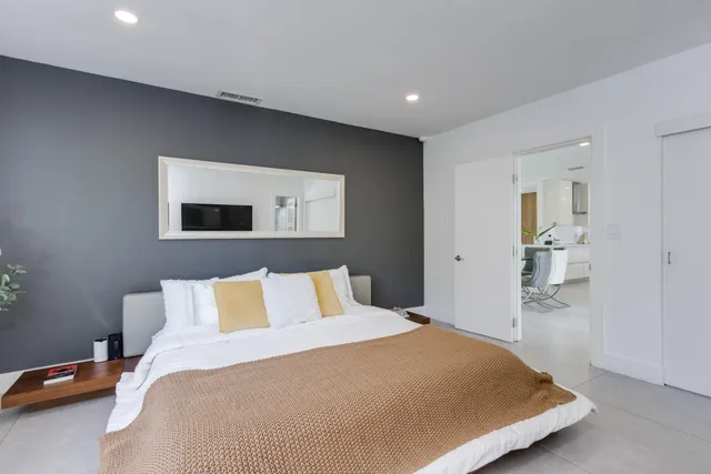 a view of a swimming pool with a yard and palm trees