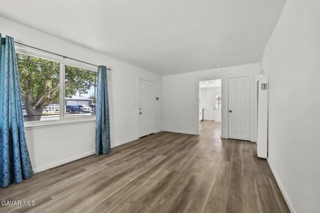 a large white kitchen with a sink a refrigerator and white cabinets