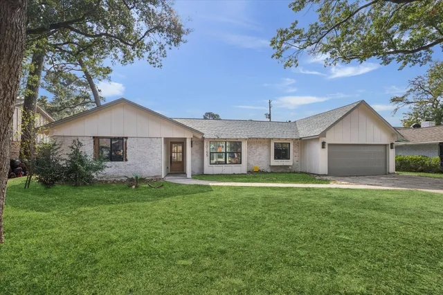 a front view of a house with a yard and trees