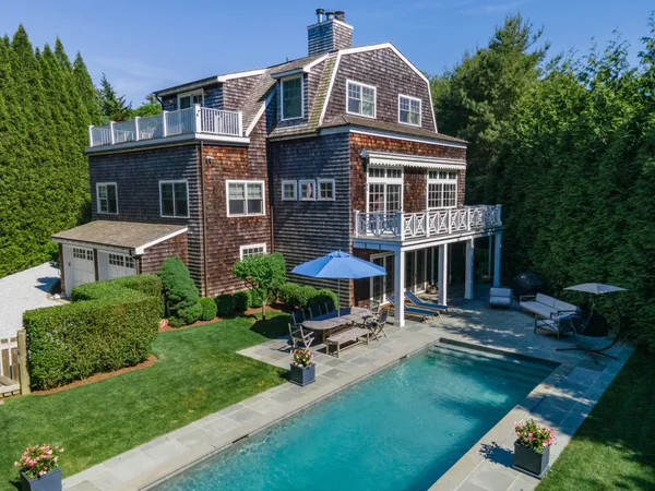 a view of a brick house with a yard patio and plants