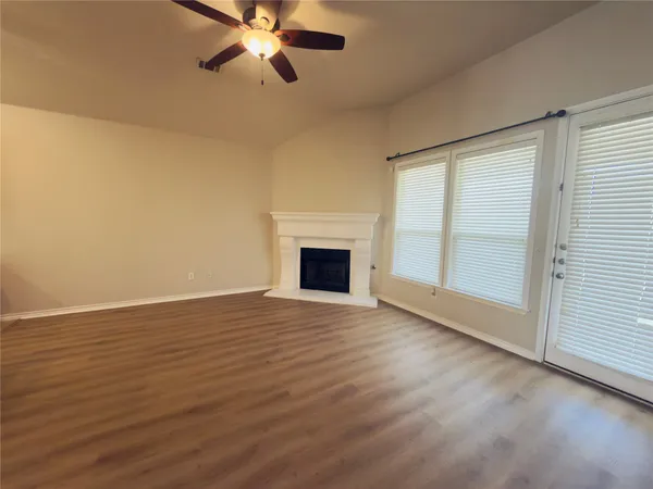 a view of a living room with wooden floor and stairs