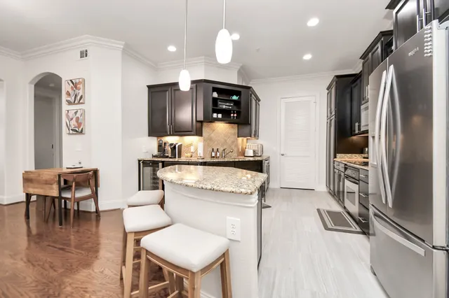 a kitchen with stainless steel appliances kitchen island granite countertop a refrigerator and a stove top oven