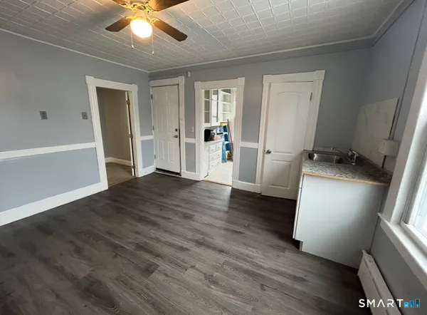 a view of a livingroom with wooden floor and staircase