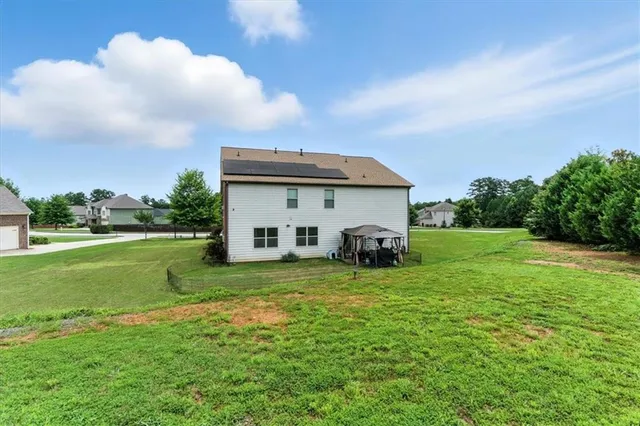 a view of a big yard with potted plants and large trees