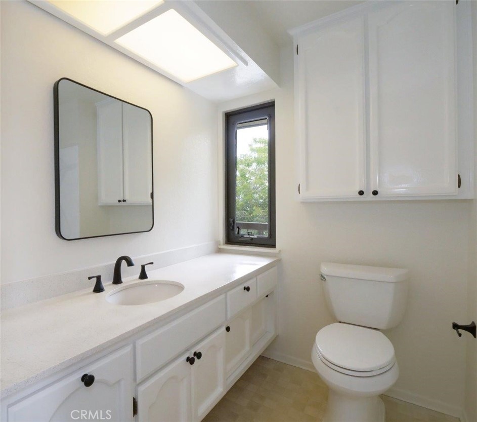 13601 Del Monte Drive, Unit 75 Seal Beach, CA 90740 - Photo 20 of 28 a bathroom with a toilet sink and mirror
