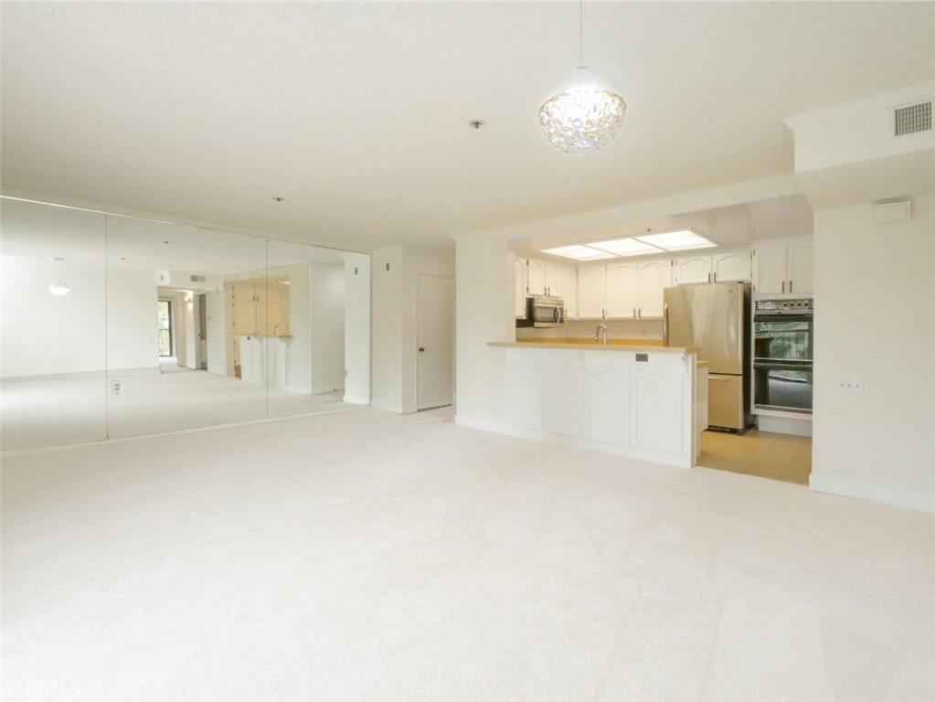 13601 Del Monte Drive, Unit 75 Seal Beach, CA 90740 - Photo 6 of 28 a view of a kitchen with a sink and a refrigerator