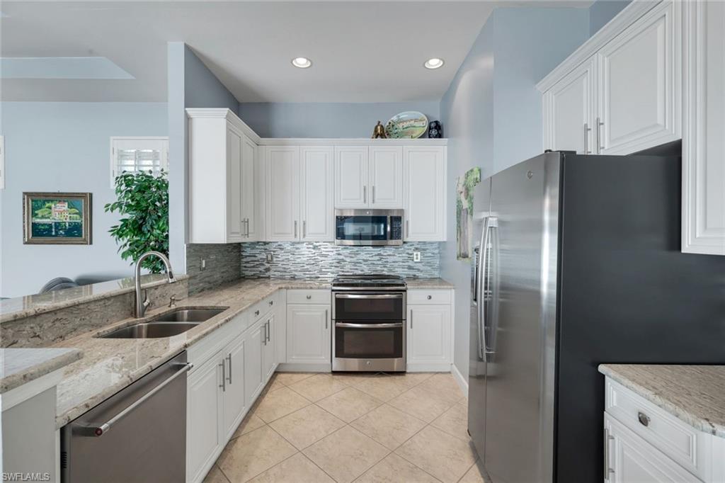 3232 Sundance Circle Naples, FL 34109 - Photo 12 of 50 a kitchen with a sink stove and refrigerator