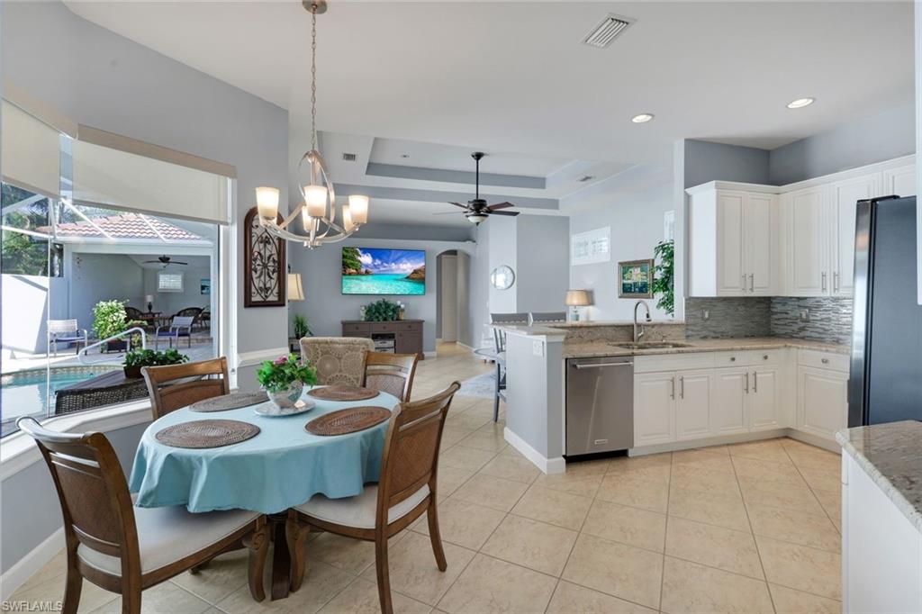 3232 Sundance Circle Naples, FL 34109 - Photo 16 of 50 a kitchen with a dining table chairs stainless steel appliances and cabinets