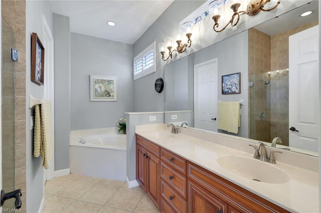3232 Sundance Circle Naples, FL 34109 - Photo 19 of 50 a bathroom with a double vanity sink a toilet a mirror and shower