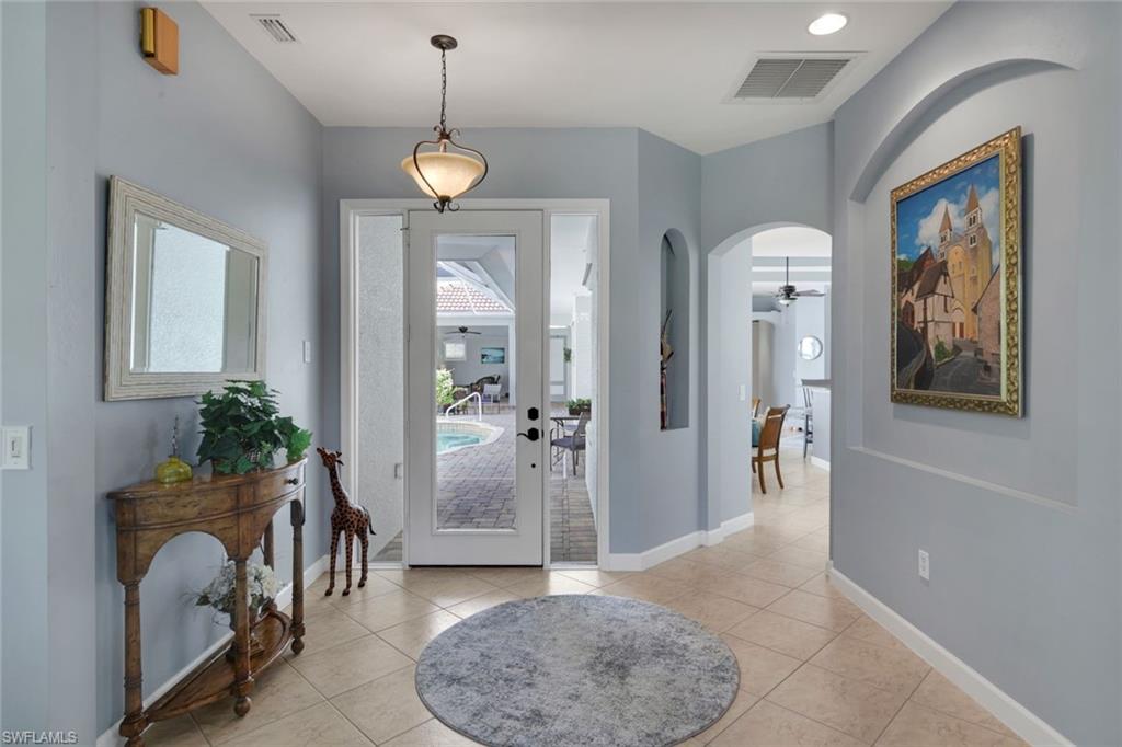 3232 Sundance Circle Naples, FL 34109 - Photo 2 of 50 a view of a hallway with furniture and a chandelier