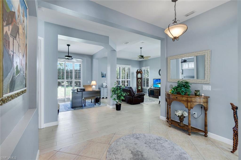3232 Sundance Circle Naples, FL 34109 - Photo 3 of 50 a living room with furniture and a chandelier