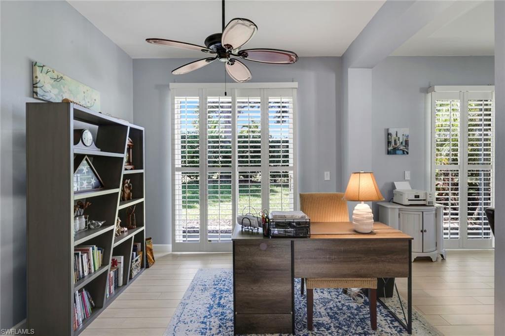 3232 Sundance Circle Naples, FL 34109 - Photo 10 of 50 a living room with furniture and a book shelf