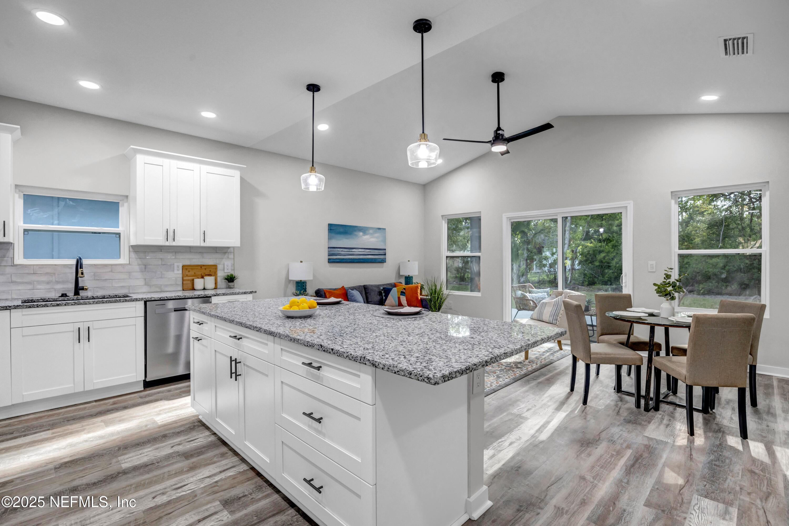 34 Delmonte Street Baldwin, FL 32234 - Photo 7 of 38 a kitchen with stainless steel appliances granite countertop stove a oven a dining table and chairs with wooden floor