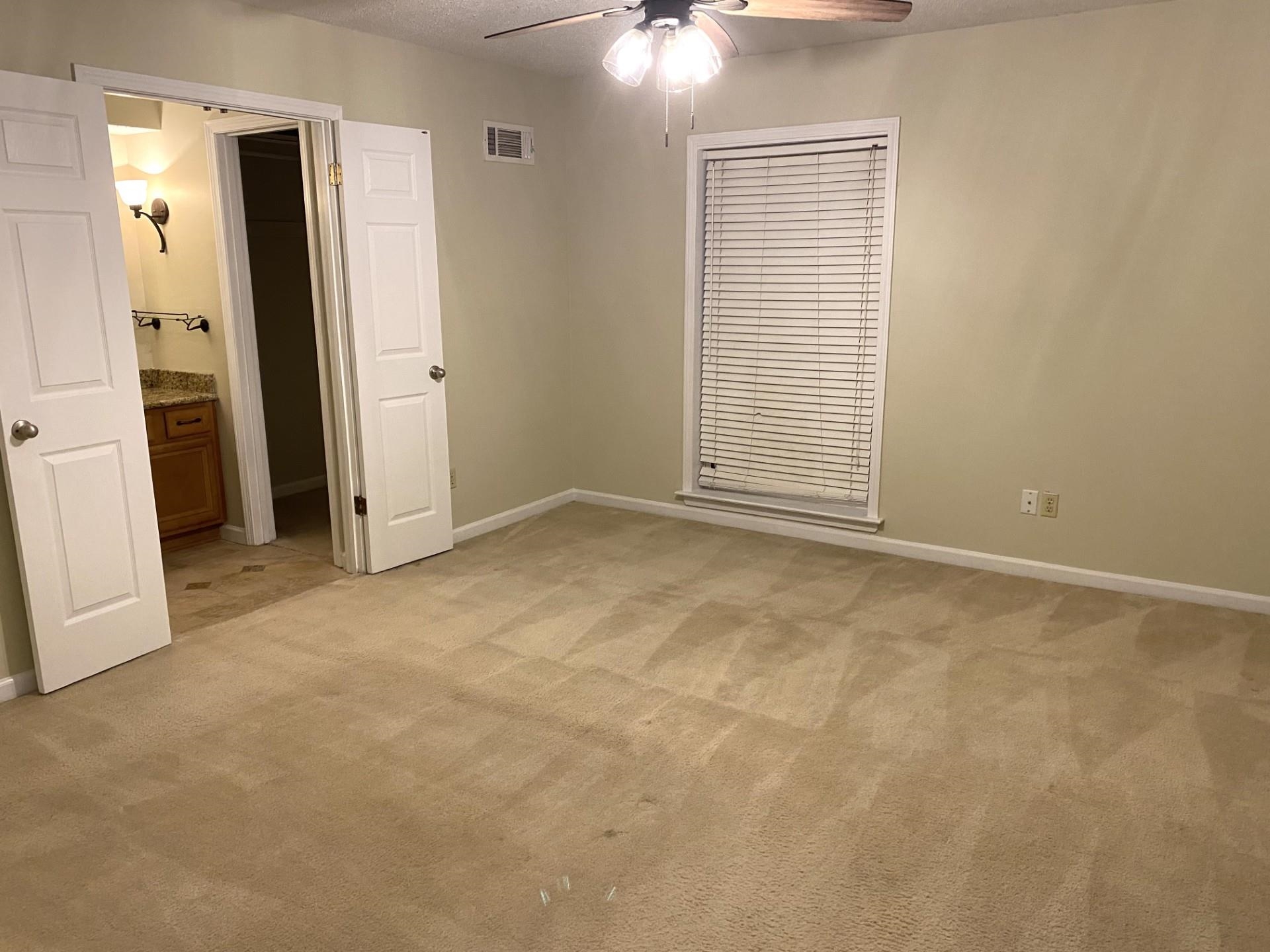 7918 Farmingdale Road Germantown, TN 38138 - Photo 5 of 12 Unfurnished bedroom featuring connected bathroom, a textured ceiling, light colored carpet, and ceiling fan