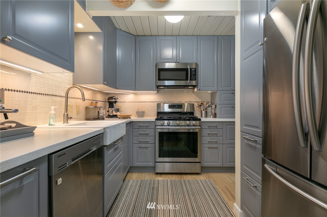 8916 Johnson Road Anderson Island, WA 98303 - Photo 8 of 22 a kitchen with stainless steel appliances a stove a sink and a refrigerator