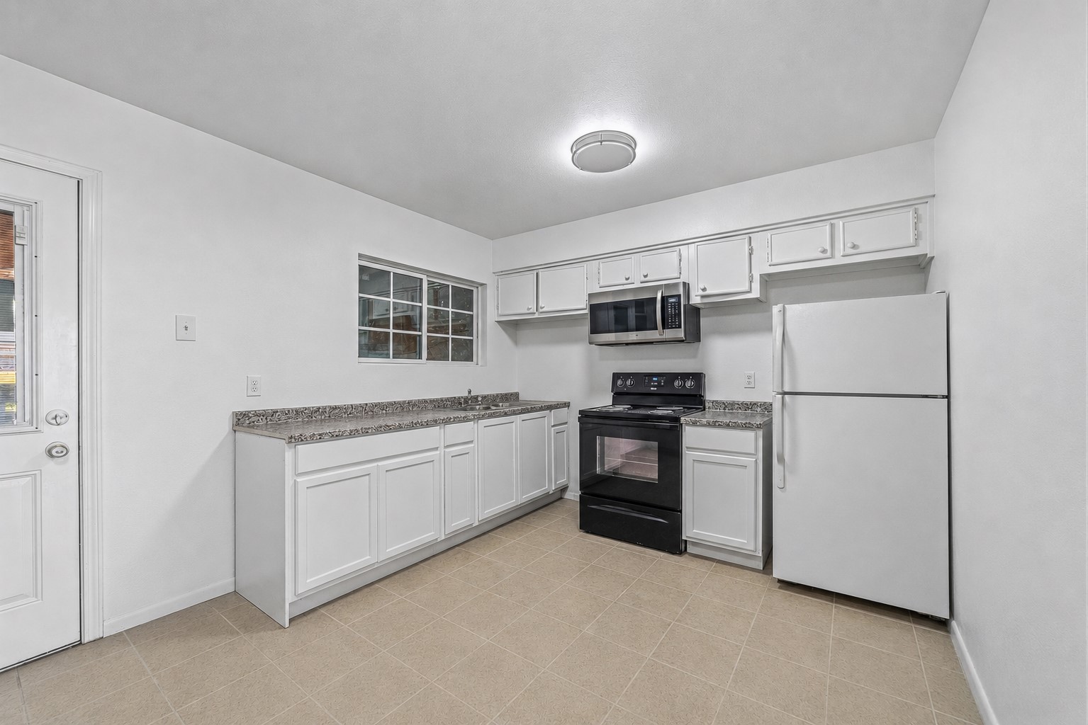 12054 Beechnut Street Houston, TX 77072 - Photo 6 of 21 a kitchen with stainless steel appliances white cabinets and a refrigerator