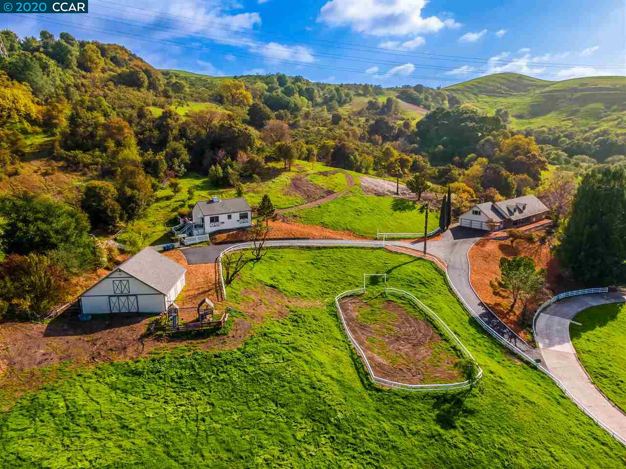 an aerial view of residential houses with outdoor space and a lake view