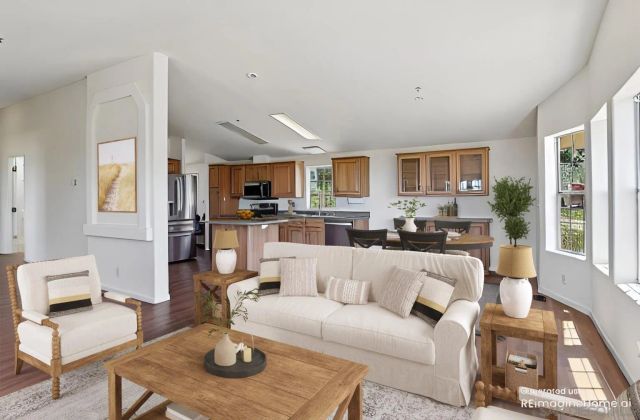 a living room with furniture a kitchen view and a fireplace
