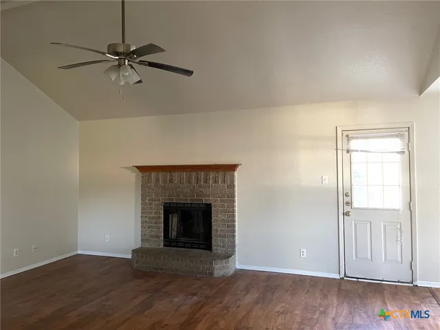 a view of a livingroom with a fireplace and wooden floor