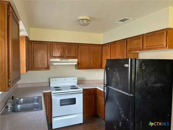 a kitchen with a stove and a refrigerator