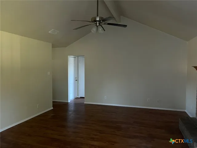 a view of a room with wooden floor and a ceiling fan