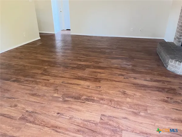 a view of an empty room and wooden floor