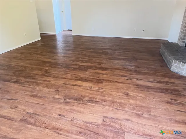 a view of an empty room and wooden floor