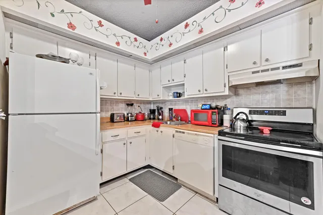 a kitchen with cabinets and white stainless steel appliances